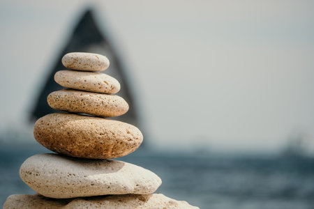 Balanced rock pyramid on the pebbled beach is a study in harmony and balance golden sea bokeh provide a stunning backdrop at sunset zen stones invite meditation and calm spa or wellness concept