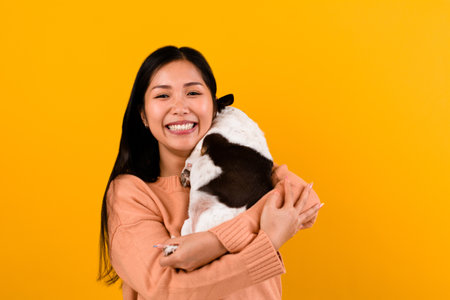 Linda mujer asiática con su amante de los perros chihuahua chihuahua la felicidad de una chica que ama a su perro el amor de la gente y la sesión de fotos de perros lindos en un estudio naranja