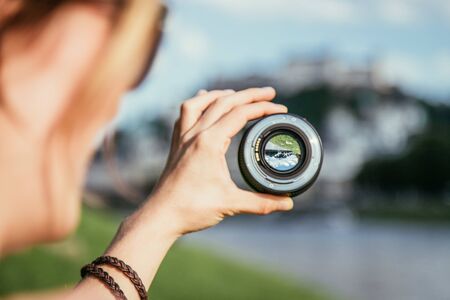 Hand holding camera lens with old city of salzburg in it close up Stock Photo