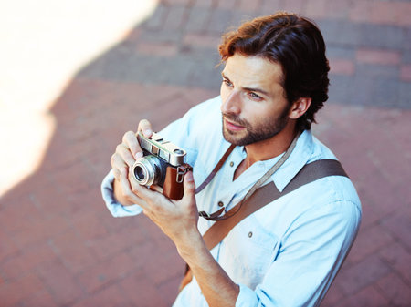 Capture memories a handsome young tourist holding his camera Stock Photo