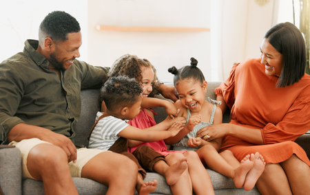 Una feliz familia de raza mixta de cinco personas relajándose en el sofá de casa. amorosa familia negra siendo juguetona en el sofá. pareja joven uniéndose con sus hijos adoptivos en casa Foto de archivo