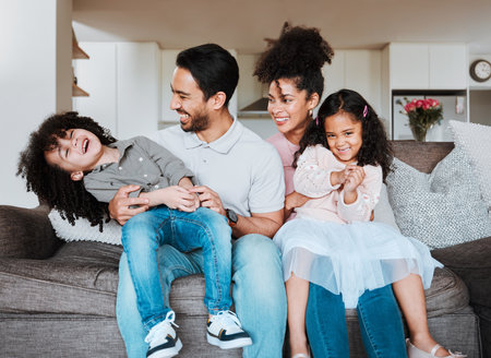 Mamá, papá y sus hijos en el sofá jugando y una familia feliz uniéndose en la sala de estar en México sonríen de felicidad y los padres se relajan con los niños en el sofá, tiempo de calidad y diversión en un nuevo hogar o apartamento Foto de archivo