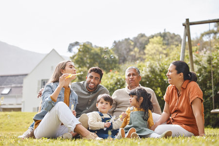 Los grandes abuelos y los niños de la familia para un picnic se relajan y las burbujas en el césped o el jardín al aire libre en verano aman a las personas y a los niños en el patio trasero de la casa por la libertad de cuidado y los vínculos en la naturaleza o el parque Foto de archivo