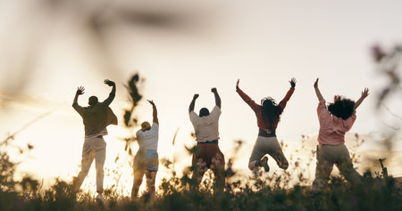 Group friends and jump or sunset field for outdoor vacation for connection holiday or milestone people community and leap in nature for agriculture celebration in countryside land or back view Stock Photo