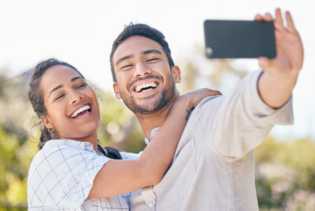 Una pareja sonríe a la naturaleza y se selfie juntos para publicaciones en las redes sociales y memoria para una relación sana, mujer feliz, hombre y fotografía o transmisión en vivo en el jardín para una cita romántica al aire libre y un vlog de verano Foto de archivo