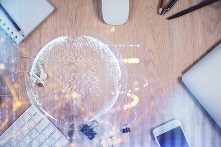 Double exposure of map hologram drawing over desktop Stock Photo