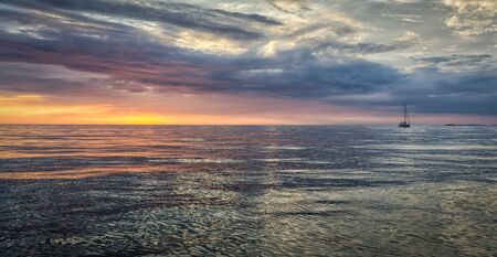 mar puesta de sol vista idílica con velero solitario