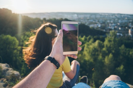 Woman with man sitting on the top of the hill injoy view on sunset Stock Photo