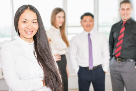 Successful asian business woman with magnificent long hair and there is business team at background