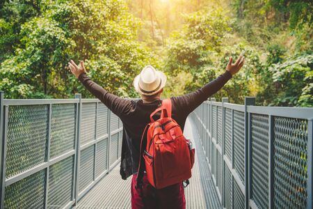 Traveling backpacker walking on canopy walkway at queen sirikit botanic garden chiangmai thailand