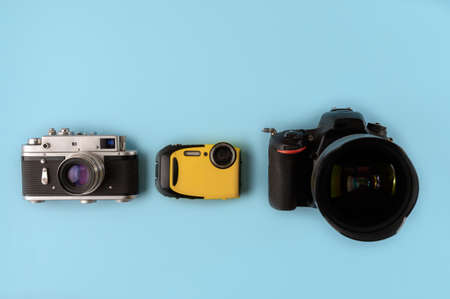 Camera evolution cameras of different types and generations on a blue background top view flat lay three cameras of different generations on a blue background technological progress of cameras