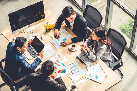 Reunión de grupo de personas de negocios tomada desde la vista superior en la oficina. Profesión empresarias, hombres de negocios y oficinistas que trabajan en una conferencia de equipo con un documento de planificación de proyectos en la mesa de reuniones.