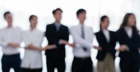 Blurry image of businesspeople holding their hand in line as to show concept of unity teamwork and harmony in office workplace office worker standing in line and join hands as collective from