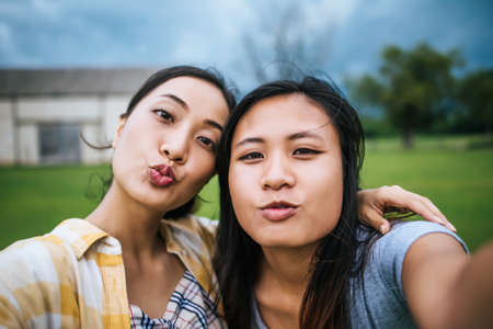 La amistad de las mujeres adolescentes mirando a la cámara hace selfie.