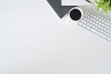 Flat lay top view office desk workspace with keyboard and office supplies with coffee on white background Stock Photo