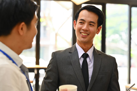 Attentive asian male manager listening to his colleague explanations during meeting