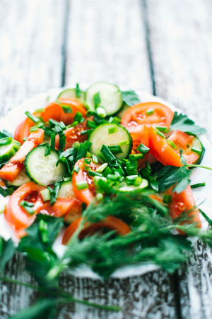 Fresh salad with vegetables on an old wooden background the concept of a diet