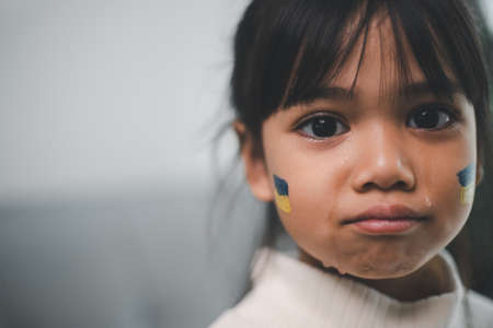 Un niño con la bandera de Ucrania está llorando. tristeza anhelo esperanza. las lágrimas de los niños de la guerra. evacuación de civiles. libertad a ucrania