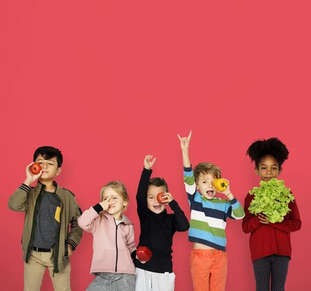 Niños pequeños sosteniendo vegetales saludables Foto de archivo