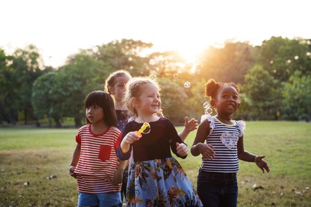 Grupo de niños soplando burbujas en el parque