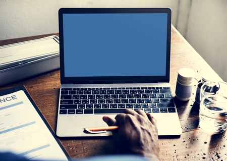 Rear view of people using computer laptop showing empty blue screen Stock Photo