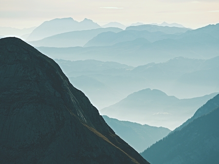 View over high sharp mountain peaks from plane beautiful view fantastic dreamy sunrise sharp contour of mountain above mist dreamy unlear view