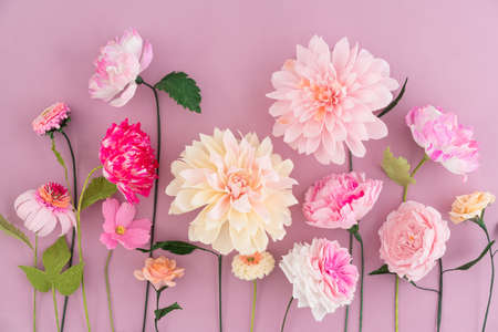 Flores de papel crepé sobre fondo de madera rosa