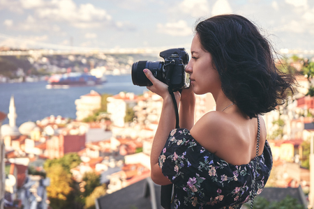 Woman photographer taking pictures of landscape in old district in istanbul