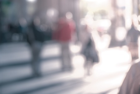 People walking down the street in the evening beautiful light at sunset the photo is purposely made out of focus no faces are recognisible