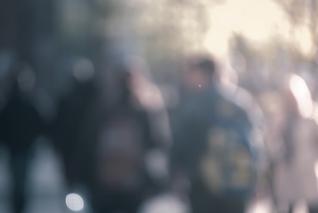 People walking down the street in the evening beautiful light at sunset the photo is purposely made out of focus no faces are recognisible Stock Photo