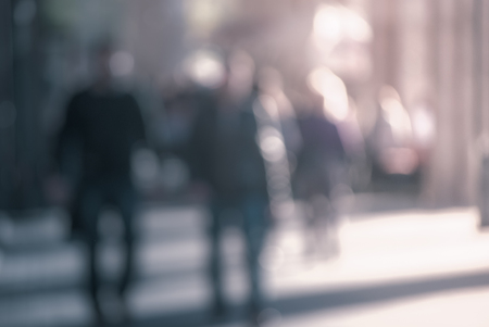 People walking down the street in the evening beautiful light at sunset the photo is purposely made out of focus no faces are recognisible