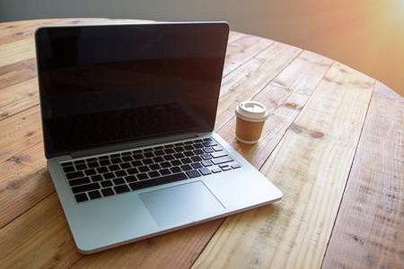 Laptop with tablet and a cup of fresh coffee on wooden table in coffee shop Stock Photo