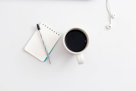 White office desk with notebook and pen and headphone top view with copy space flat lay Stock Photo