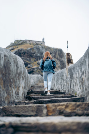 Woman climbing stairs in san juan de gaztelugatxe