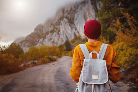 Outdoor fashion photo of young beautiful asian lady surrounded autumn forest in mountains portrait of romantic hipster female warm autumn weather calm scene wanderlust photo series