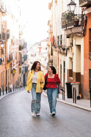 Joven asiática divirtiéndose en la ciudad de madrid y hablando con su amiga