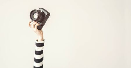 Young female raised up arm and holding camera Stock Photo