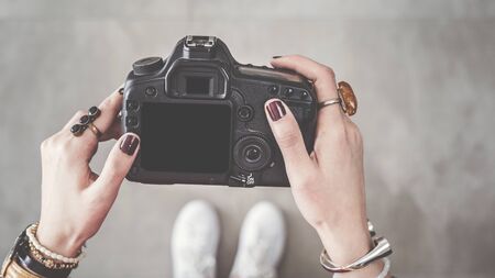 Woman holding digital camera high angle view