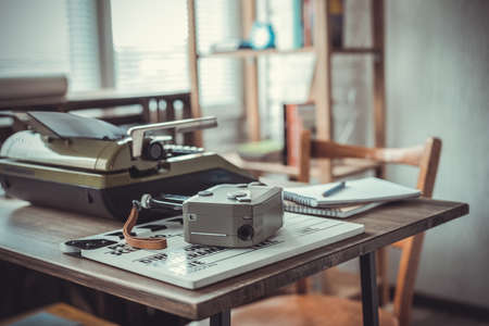 Vintage old film camera and typewriter at wooden desk table writer or screenwriter creative concept Stock Photo