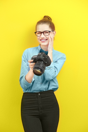 Mooie jonge fotograaf op kleur achtergrond