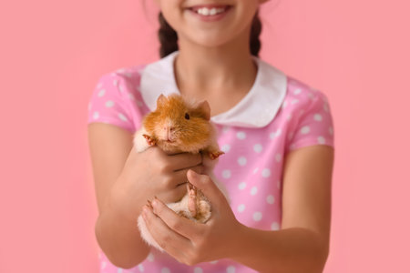 Little girl with cute guinea pig on pink background closeup