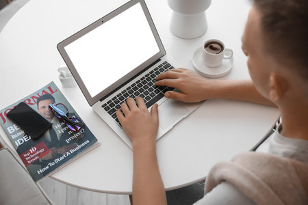 Young man using laptop at table in office closeup Stock Photo