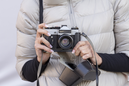 The girl with the french manicure is holding the vintage camera Stock Photo