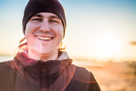 Man in sports clothes smiling outdoors close up