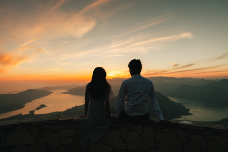 huwelijksreis koppel kussen en omhelzen bij zonsondergang bij zonsondergang silhouet. Bergen en uitzicht op zee op Kotor Bay. Montenegro Stockfoto