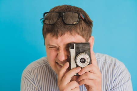 Młody człowiek sfotografowany na retro aparacie