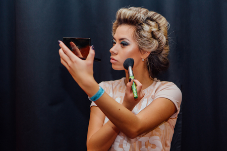 Portrait of young beautiful girl making hairdress and makeup