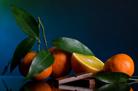 Oranges and chocolate on dark blue background Stock Photo
