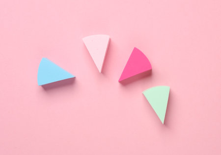 Triangular make up sponges on pink pastel background top view Stock Photo