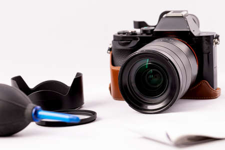 Camera with lens and a pear for optics care on a white background